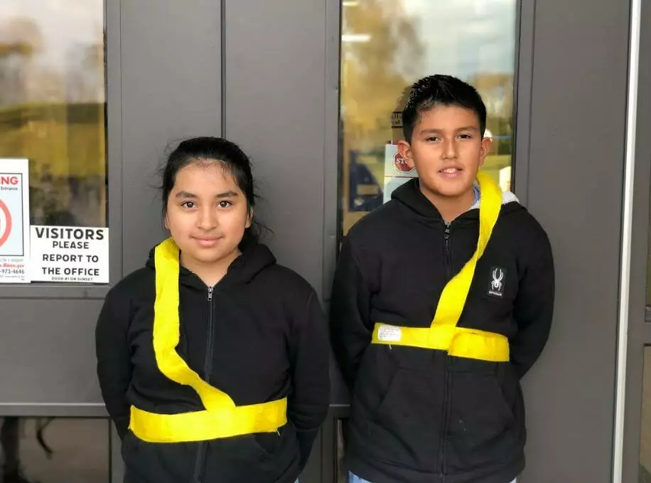 Two patrol members are ready for students to arrive. 
