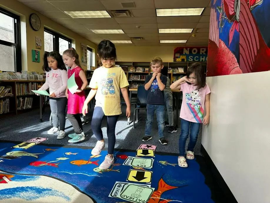 Two kinders follow the code written by their classmates