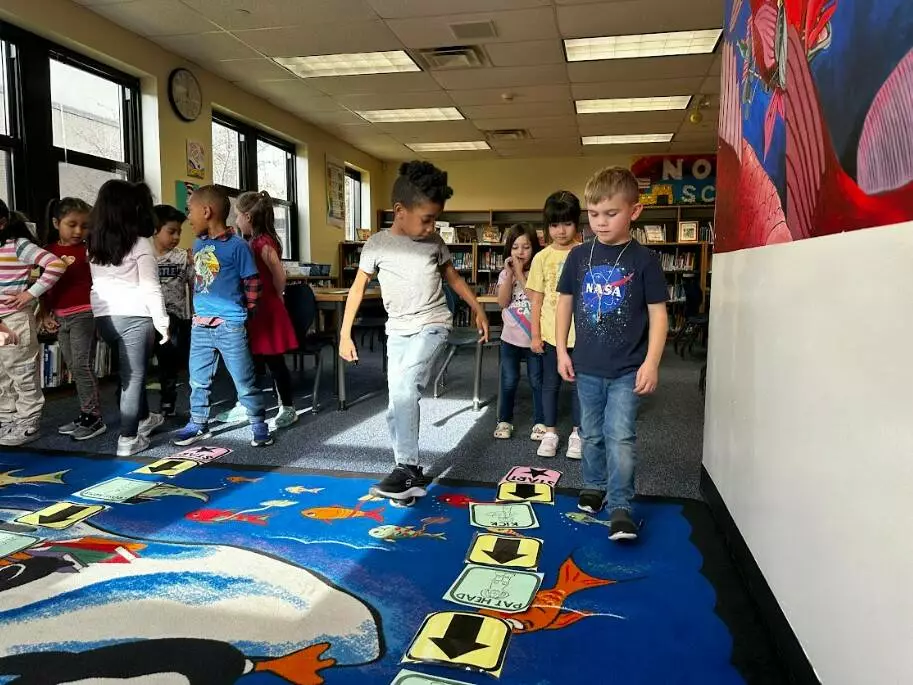 Two kinders follow the code their classmates wrote