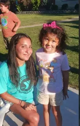 A future North kindergartener poses with a YMCA volunteer. 