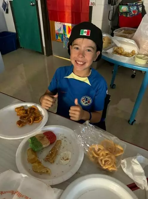 A fifth grader gives the Hispanic Heritage feast two thumbs up!