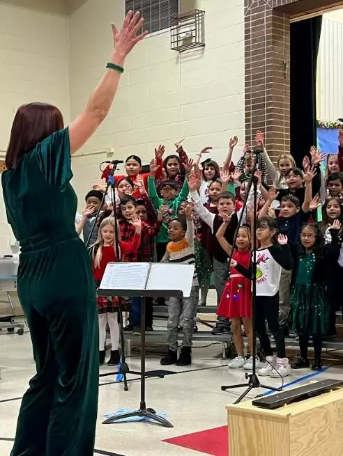 Mrs. Connelly leads the 2nd graders in performing festive winter songs.