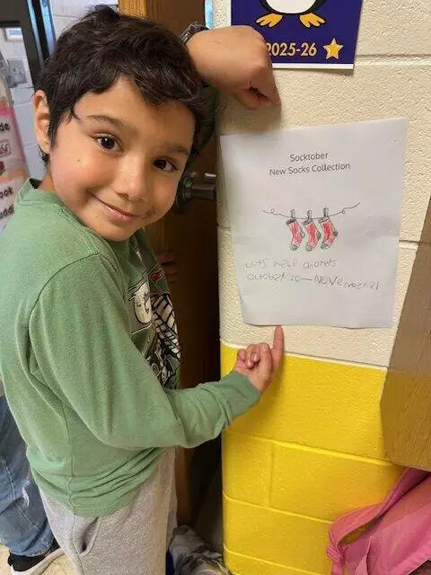A K-Kids member is proud of the sign he made.