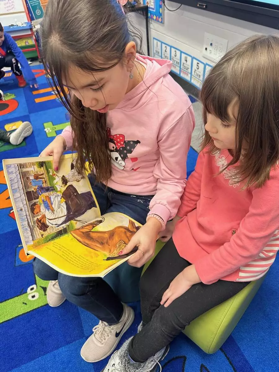 Reading buddies enjoy a story together.