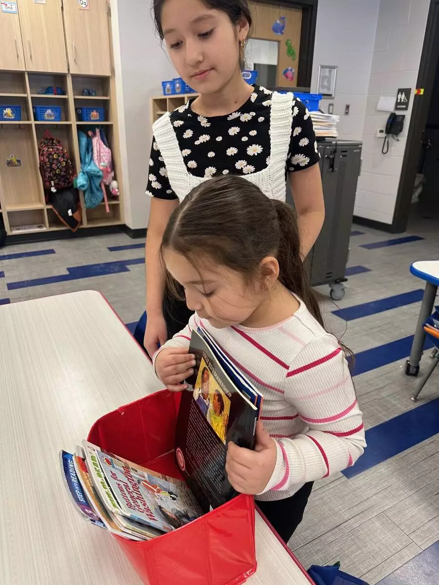A kindergartener shops for the perfect book to read with her buddy. 