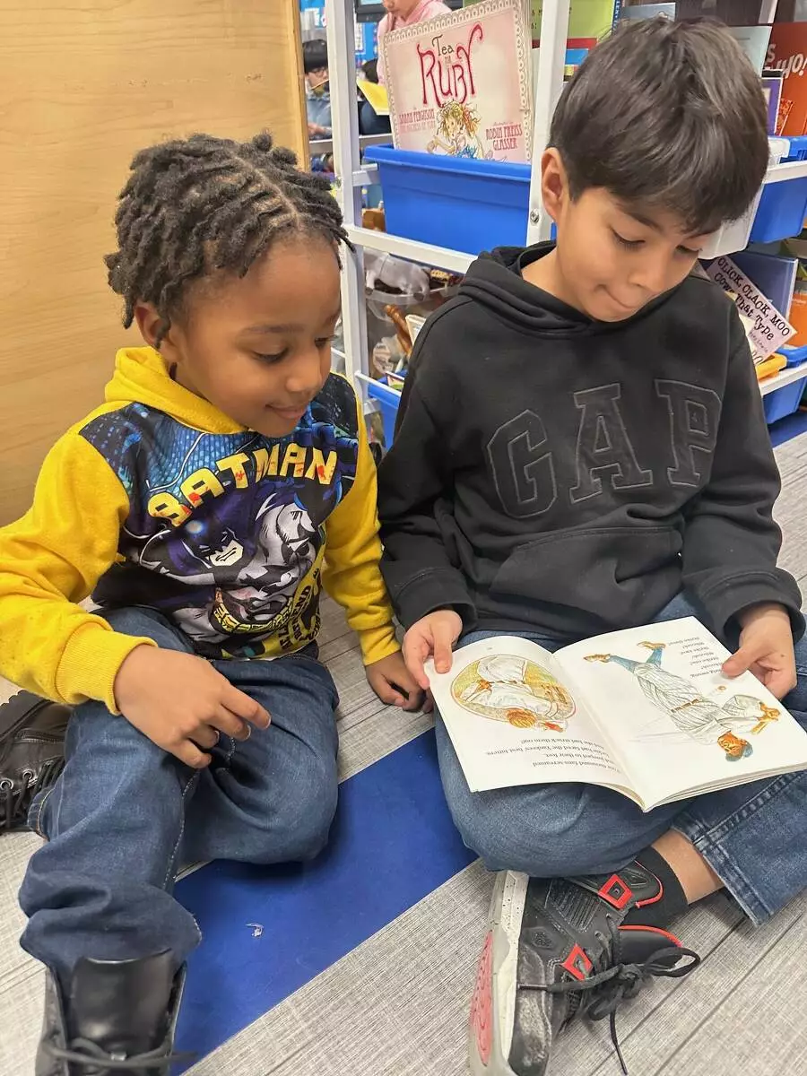 A kindergartener gets excited to read with his buddy. 