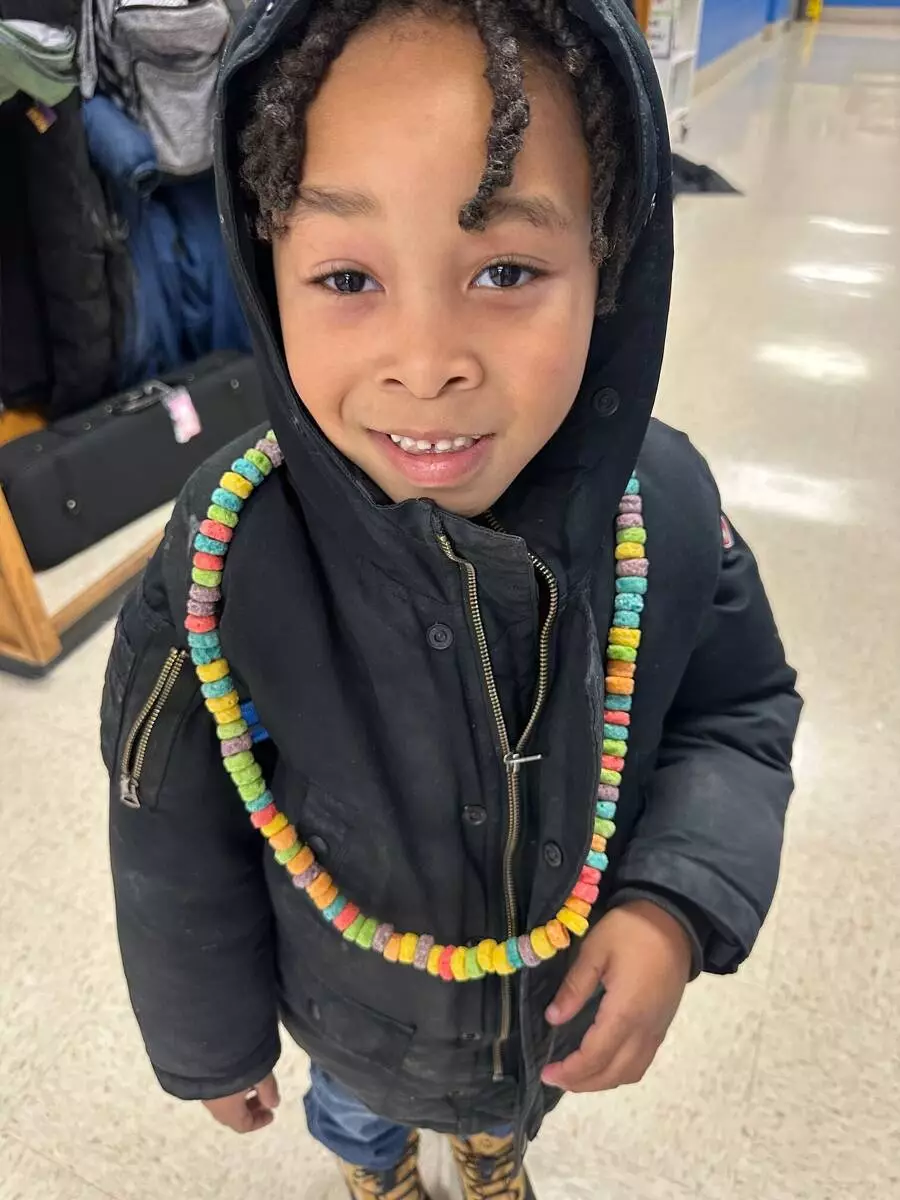 A kindergartener shows off his 100th Day necklace. 