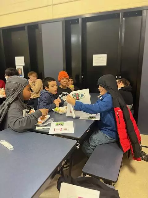 Fifth graders eat lunch and follow along with the books Mrs. Carpenter is reading. 