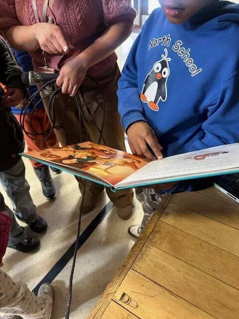 Students check out the most recent book in the running to win March Madness!